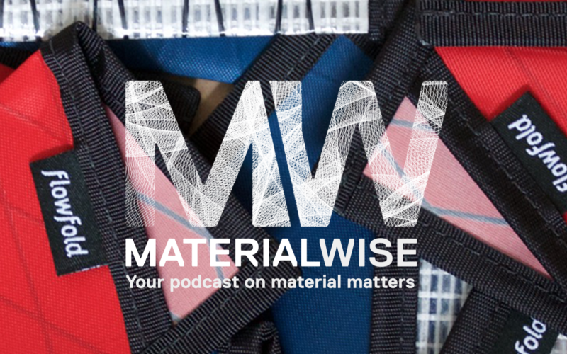 Flow fold wallets with red, pink, blue and black boarders a texture behind the material wise podcast logo.